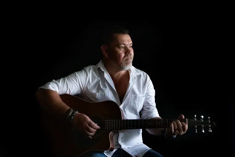 Wynand Strydom oor sy kitaar gebuig